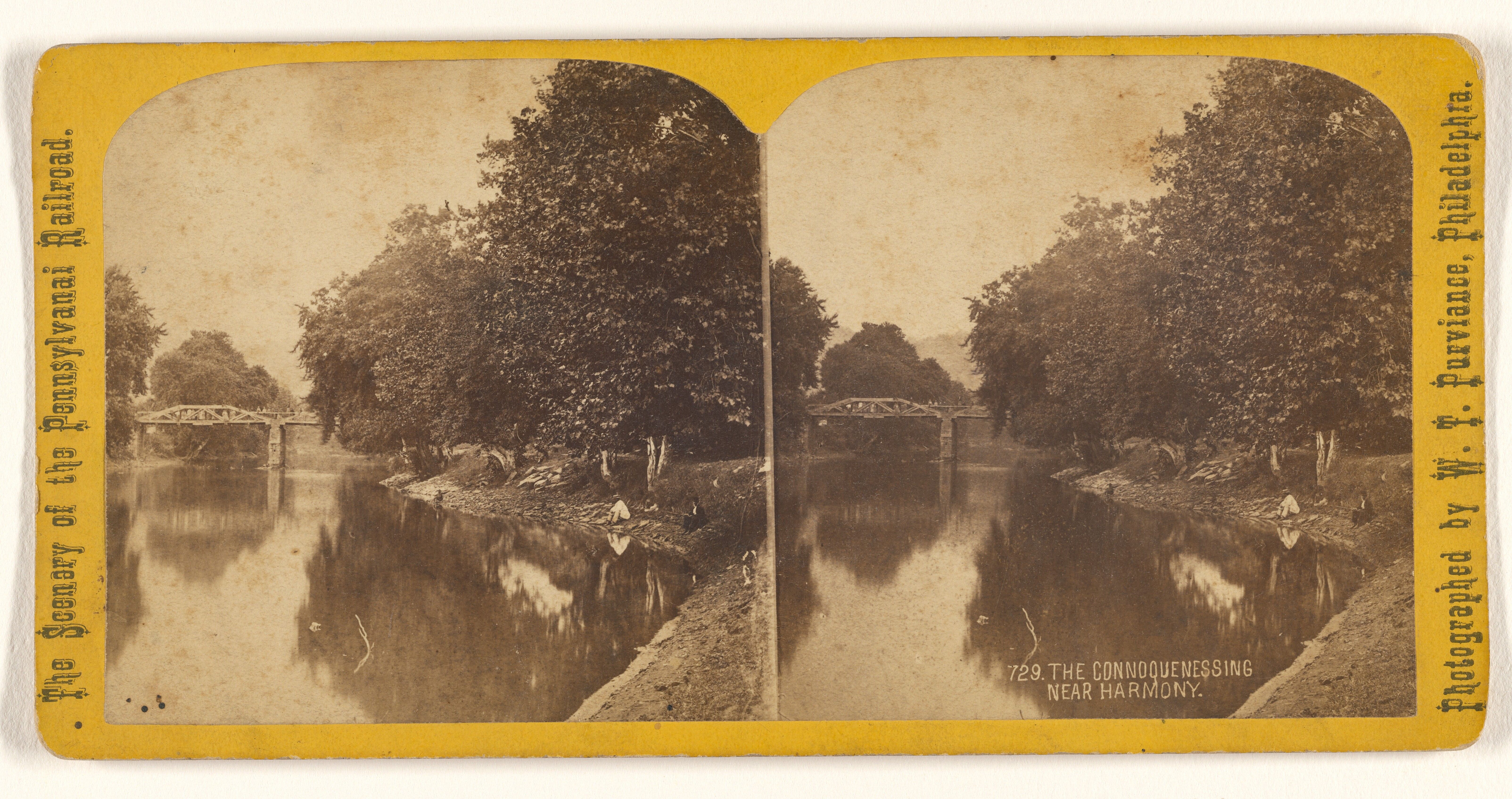 The image shows a black and white photo of a river with a bridge in the background, surrounded by...