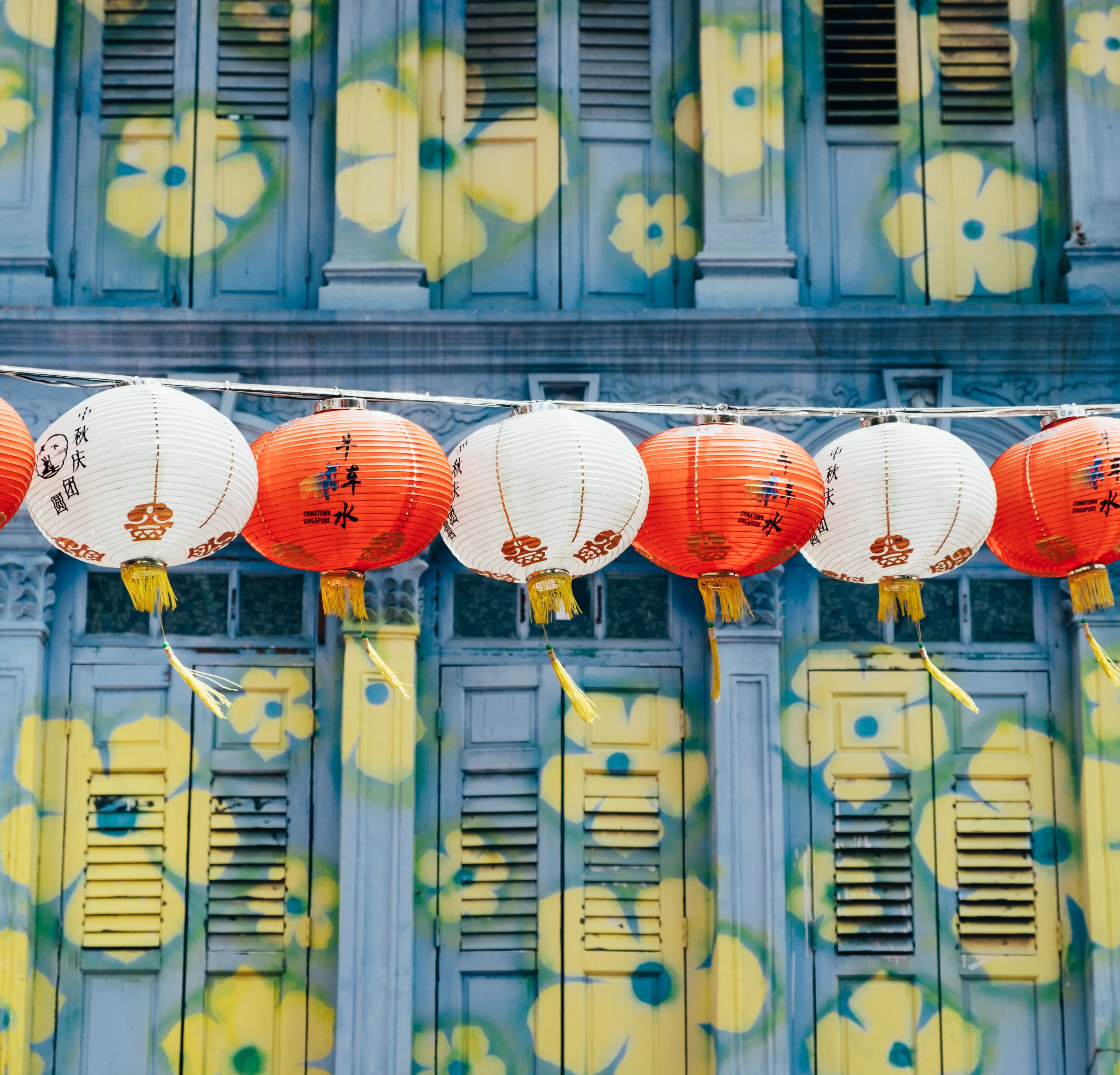 The image shows a building in Chinatown, Singapore, with colorful Chinese lanterns hanging from the...