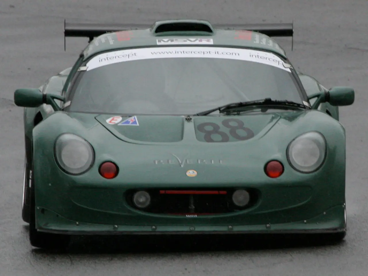 In the foreground of this picture, we see a sports car on which "88" number is written on it. In...