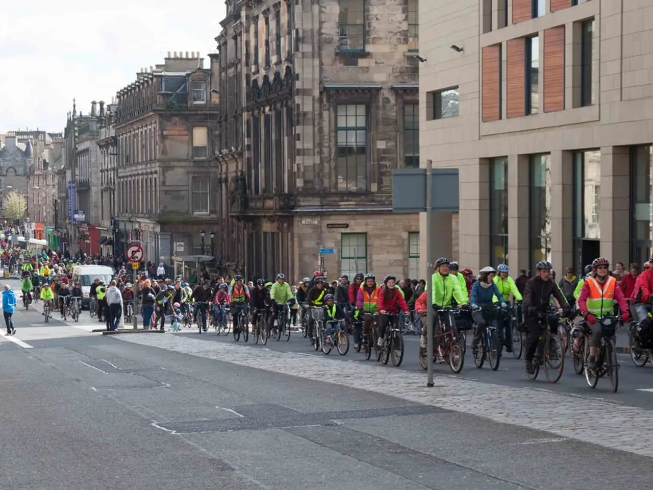 In this image I can see in the middle a group of people are riding the cycles, few of them wore...