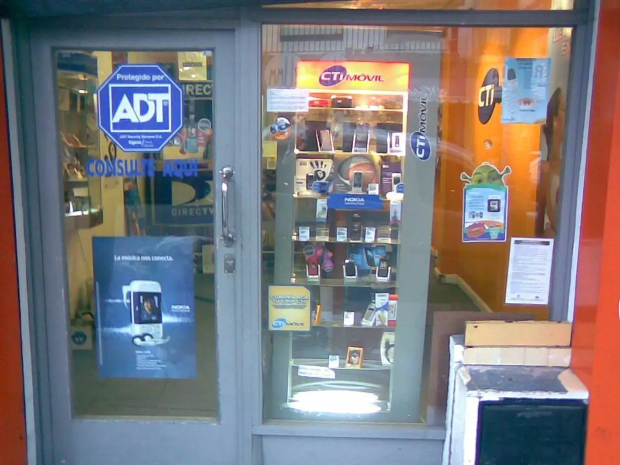 This is a picture of a mobile stall where there are labels stick to the glass , mobiles arranged in...