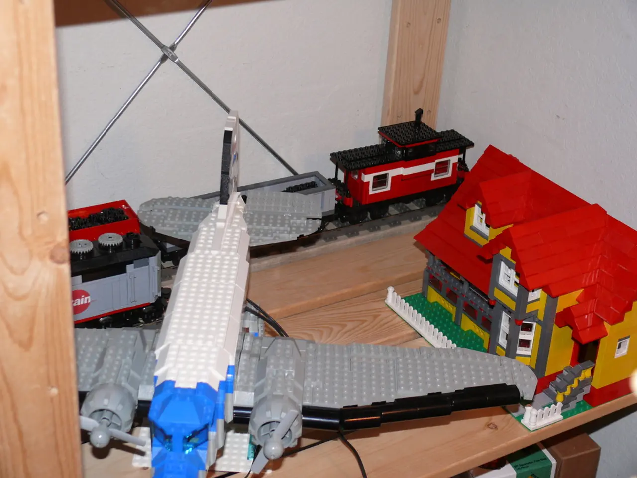 In this image, I can see the LEGO puzzle toys. I can see a train, airplane and a house, which are...
