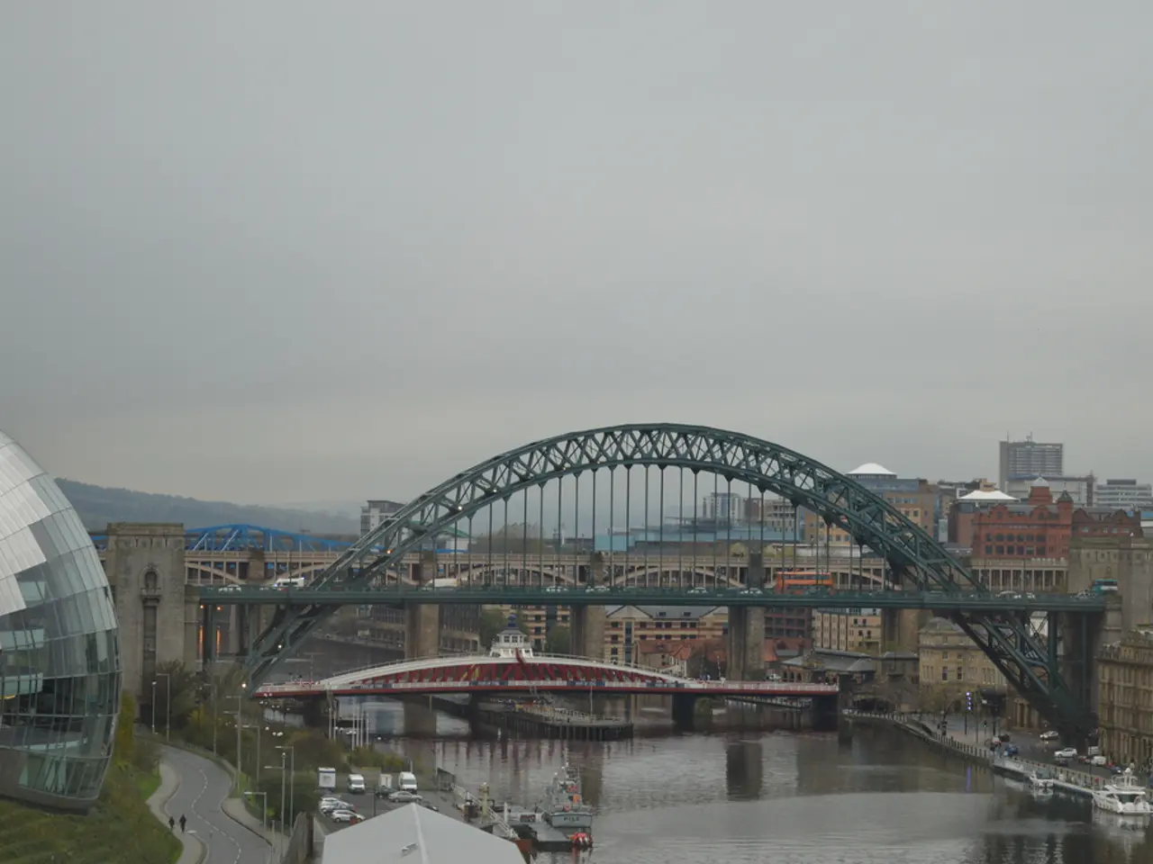 In this image there are buildings, bridges, water, architecture, cloudy sky, trees, grass, roads,...