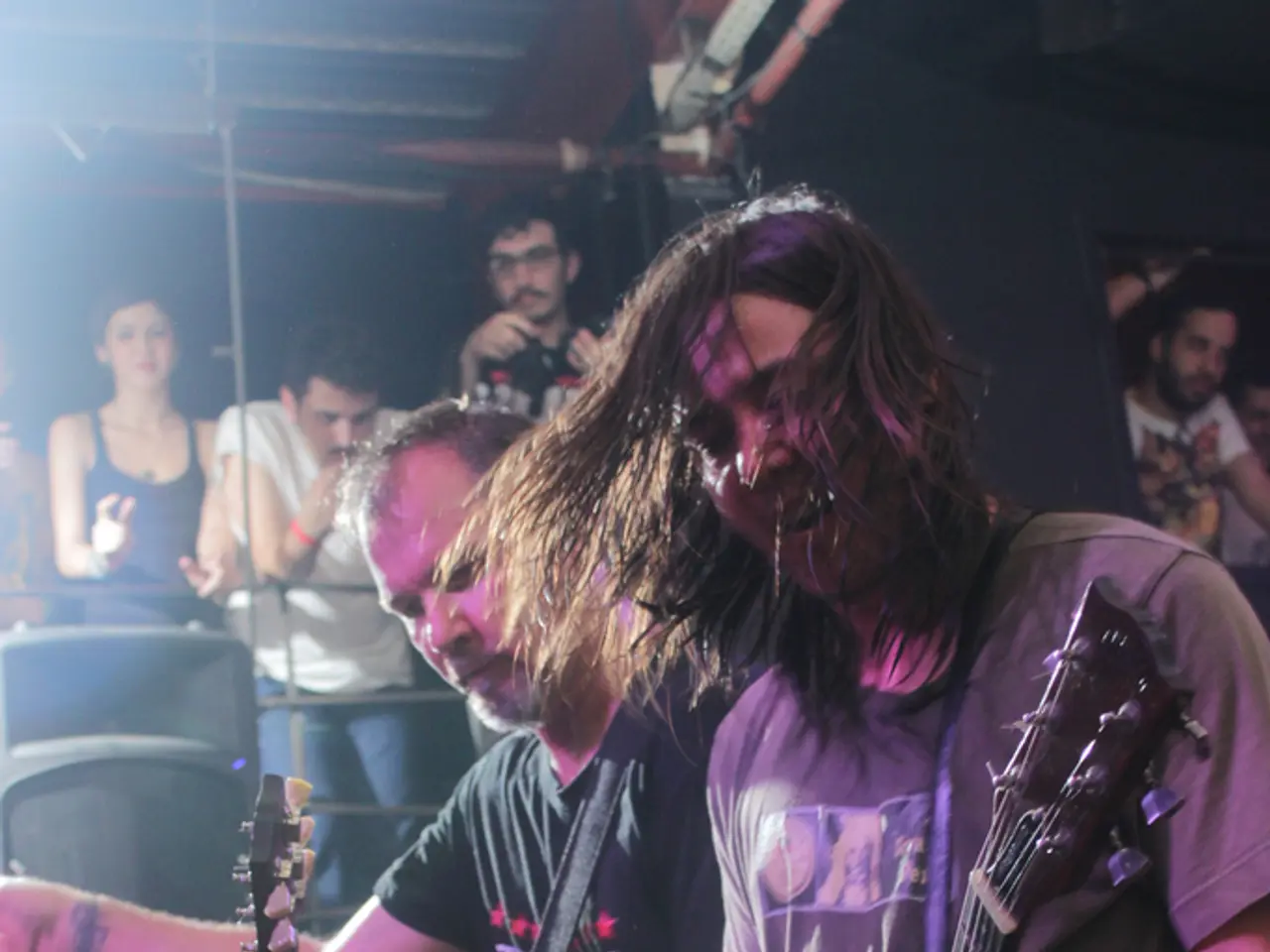 There is a group of people. They are standing and they are playing a musical instruments.