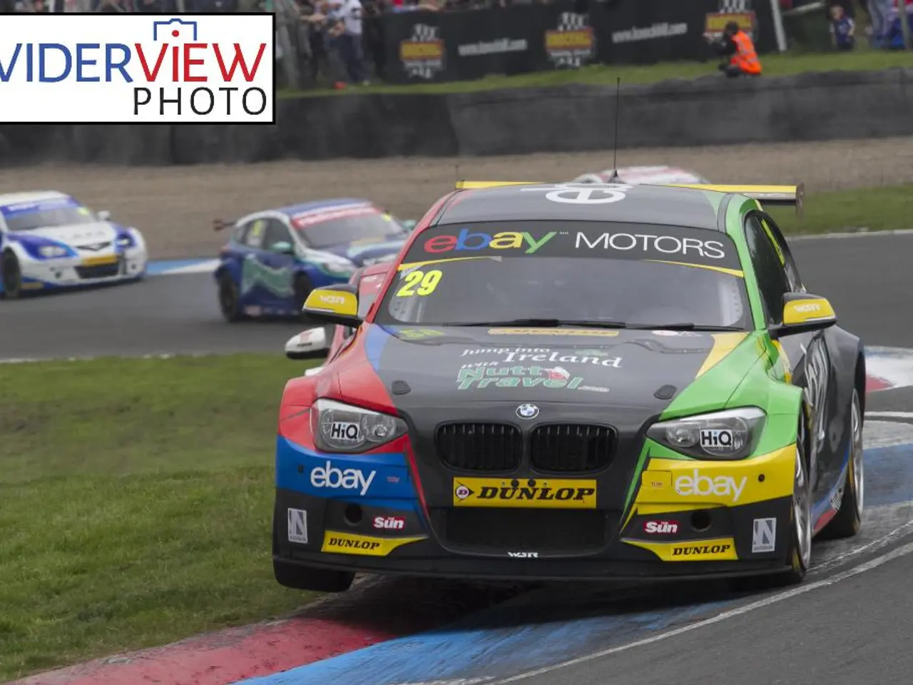 In this image there are race cars on the path , and at the background there are group of people,...