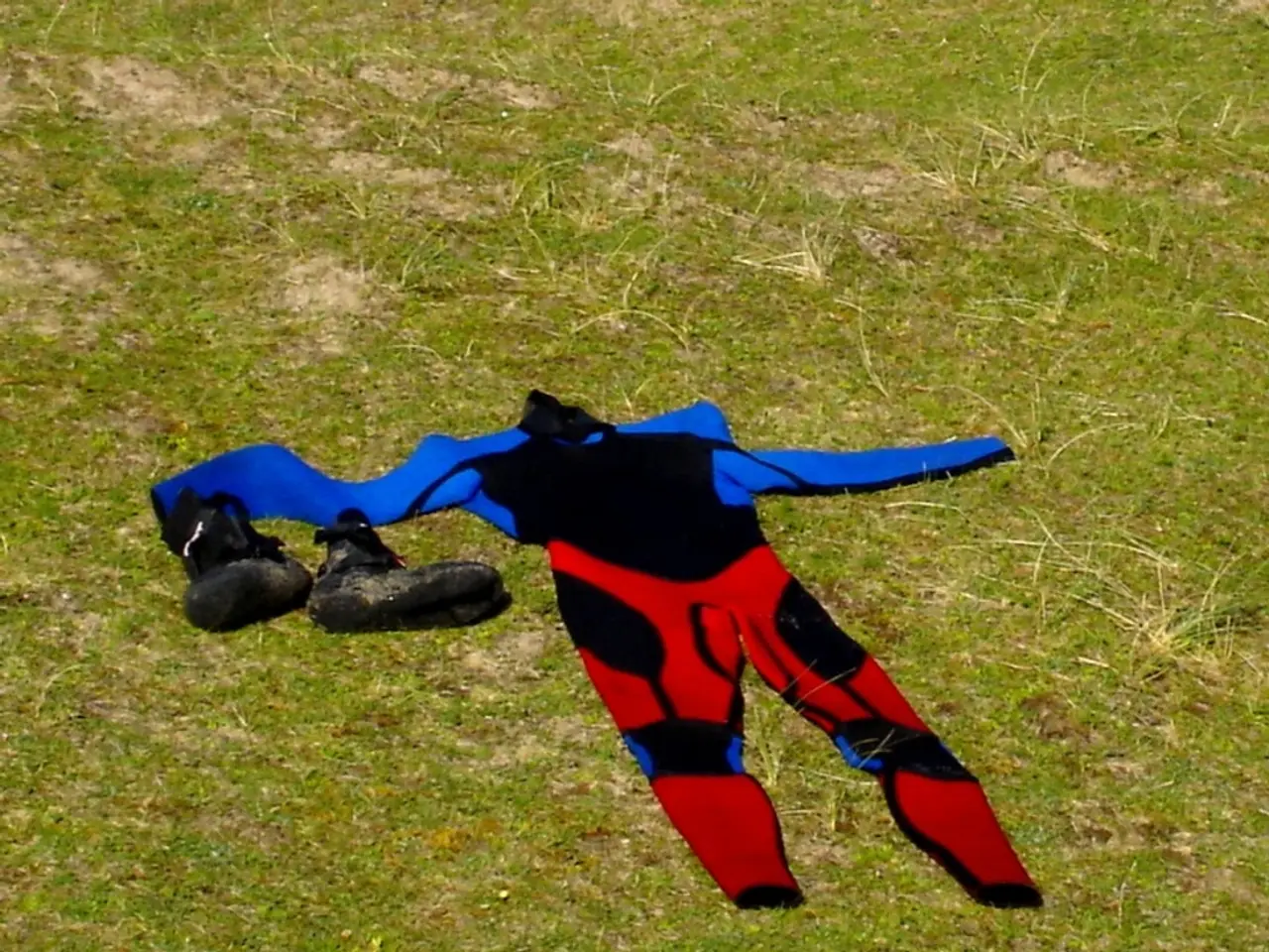 In this picture there is a dress and there are black color shoes on the grass and the dress is in...