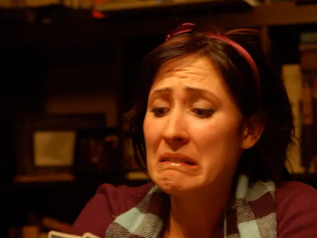 In this picture we can see a woman and she is holding cards, in front of her we can see few cards...