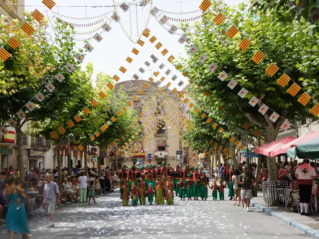 On the left side, there is a woman holding a baby and walking on the road in front of a person who...