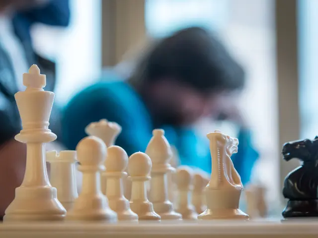 In this picture there are few chess coins and there are few persons in the background.