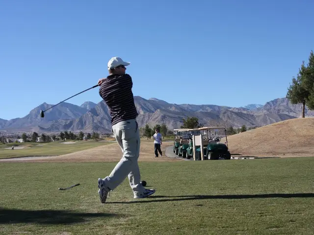 In this image in the center there is a man playing. In the background there is a man walking and...