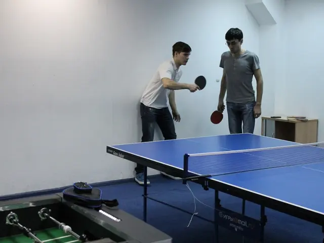 In this image I can see two are playing the game table tennis.