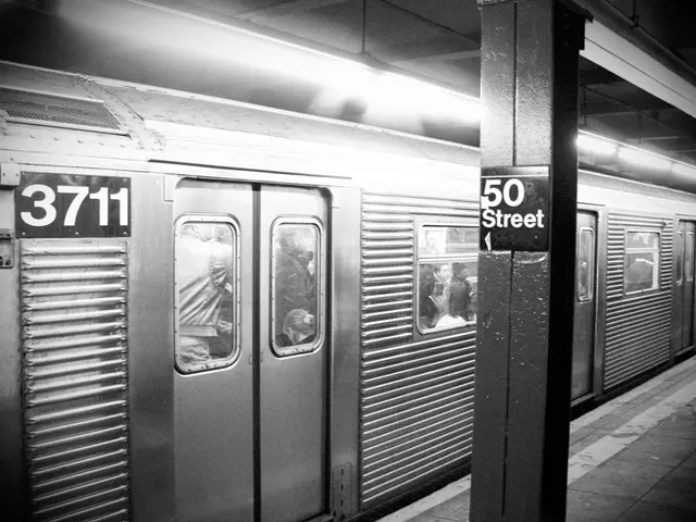 This image consists of a train in which there are many people. On the right, we can see a pillar,...