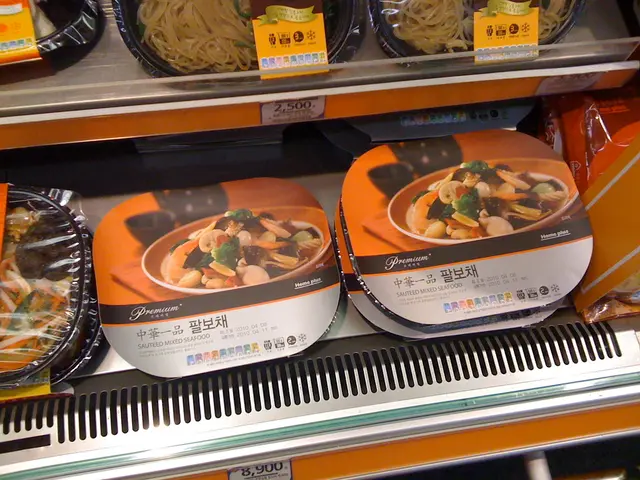 In this picture we can see food boxes in the racks. We can see price notes.