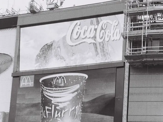 In this image in front there are people holding the pluck cards. Behind them there are buildings.