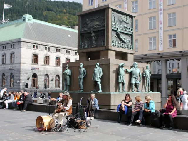 In the foreground of the image there are people. There is a lady playing musical instruments. In...