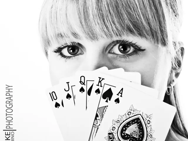 In this image there is a woman holding cards in her hand and on the left side of the image there is...