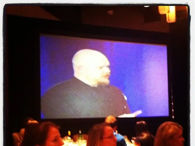 This image consists of a screen. In which we can see a man talking. At the bottom, there are many...