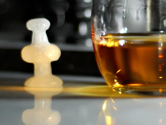 In this picture there is wine glass placed on the table top. Beside there is a white color chess...