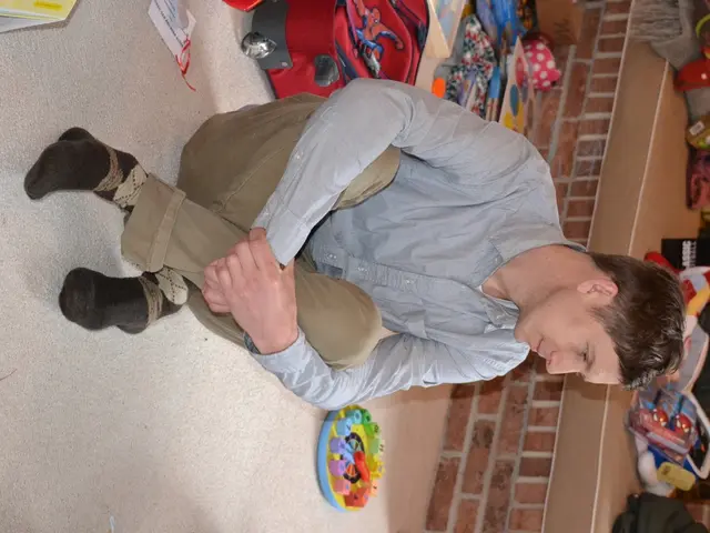 In the image we can see a man sitting wearing clothes, socks and the man is smiling. This is a...