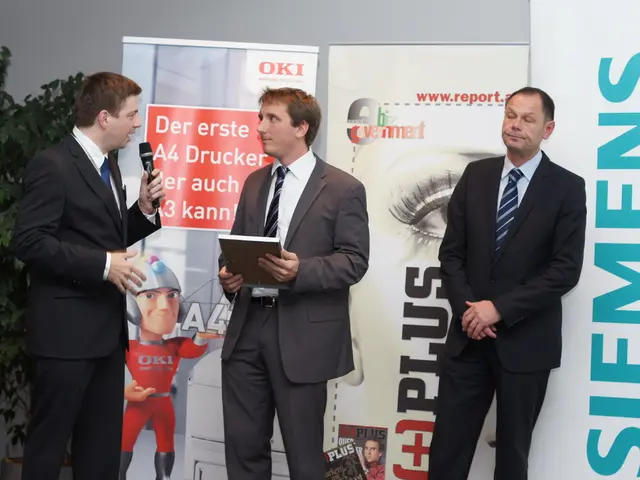 In this image there are three people standing on stage in which one of them is holding mike in hand...