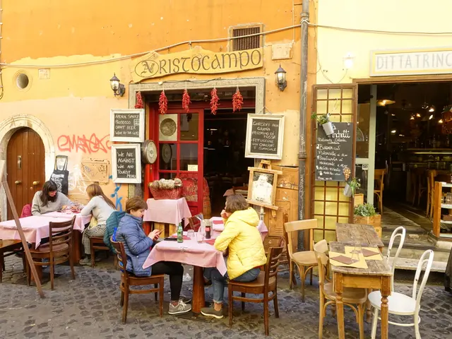The image shows a group of people sitting at tables outside of a restaurant in Rome, Italy. The...