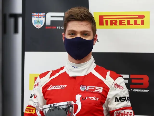 The image shows a man wearing a red and white racing suit and a face mask, proudly holding a trophy...