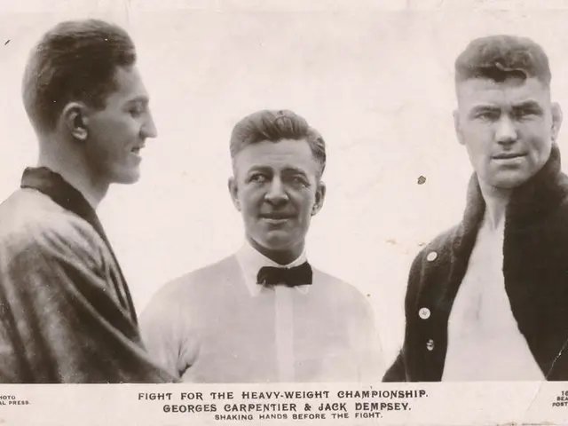 The image shows three men standing next to each other in a black and white photo. The man in the...