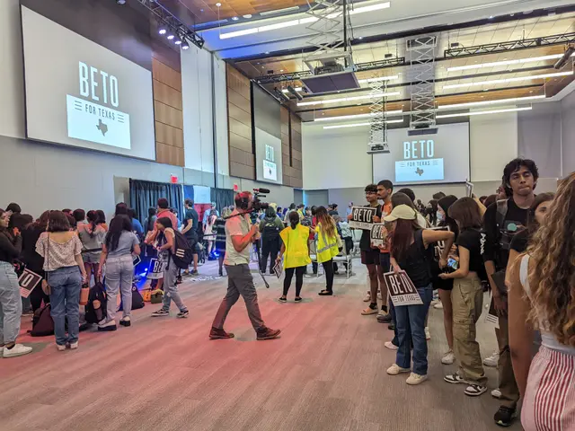 The image shows a group of people standing in front of a large screen, with some of them holding...