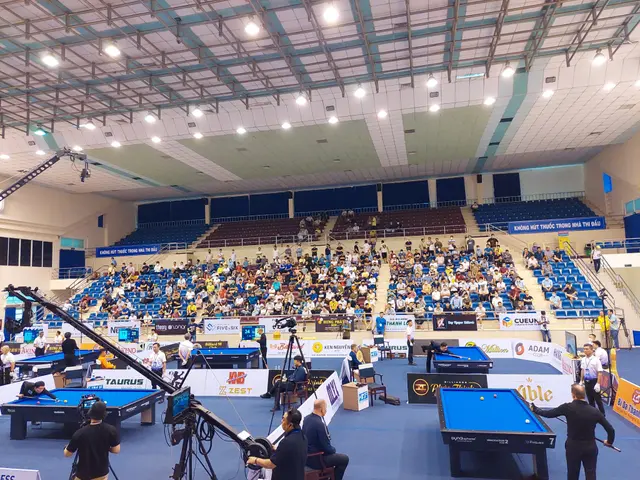 The image shows a large room filled with lots of people playing pool. There are several pool tables...