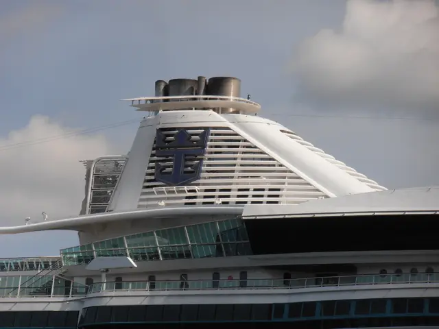The image shows Royal Caribbean's Allure of the Seas, a large white and blue cruise ship, with a...