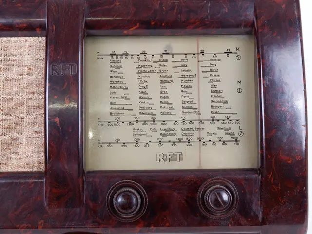 The image shows an old fashioned wooden radio sitting on top of a white table. The radio has a dial...