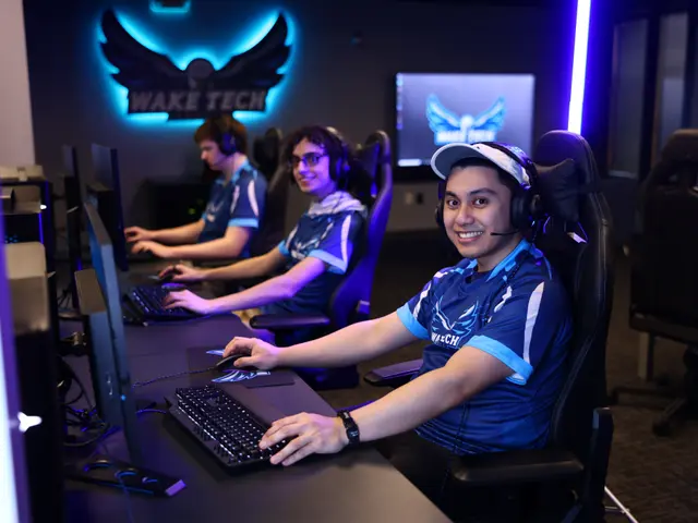 The image shows a group of people sitting at a desk in front of computers, wearing headsets and...