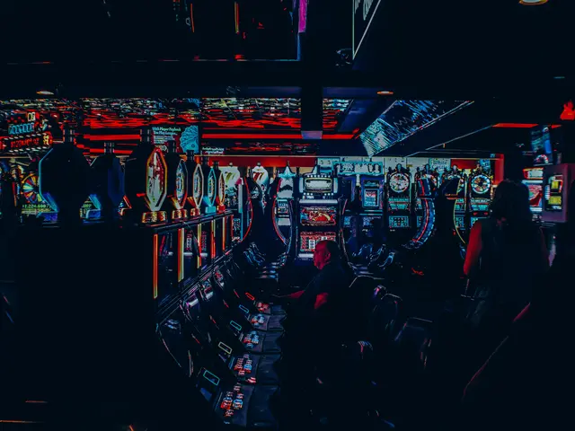 The image shows a group of people playing slot machines in a casino. There are people sitting on...