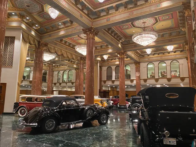 The image shows a large room filled with lots of classic cars, including a car showroom at the...