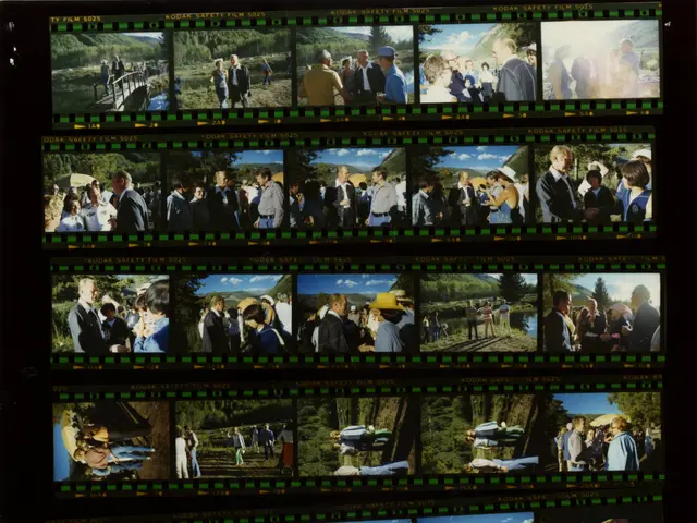 The image shows a black and white photo of a group of people standing in front of a film strip. The...