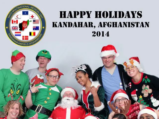 The image shows a group of people wearing festive Christmas sweaters and Santa Claus hats, posing...
