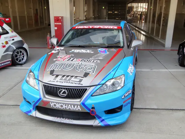 The image shows a Lexus IS F race car parked in front of a building with glass walls and pillars....