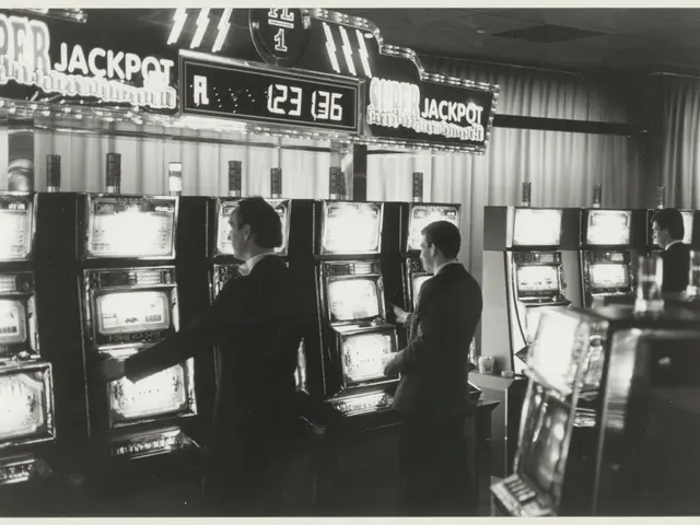 The image shows a black and white photo of two men playing slot machines in a casino. The men are...