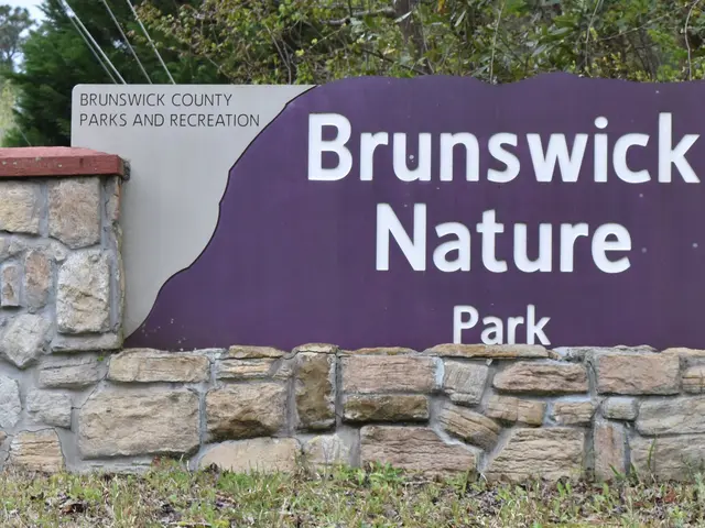 The image shows a name board on a stone wall with the words "Brunswick Nature Park" written on it,...