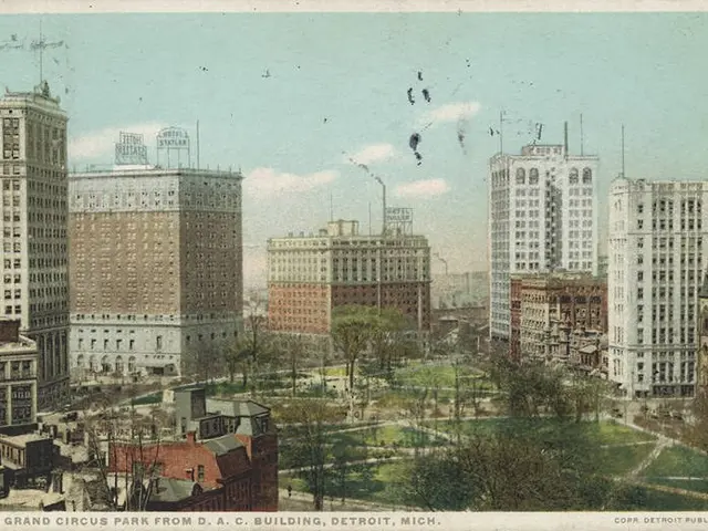 The image shows an old postcard of a city with tall buildings, trees, grass, and a sky with clouds...