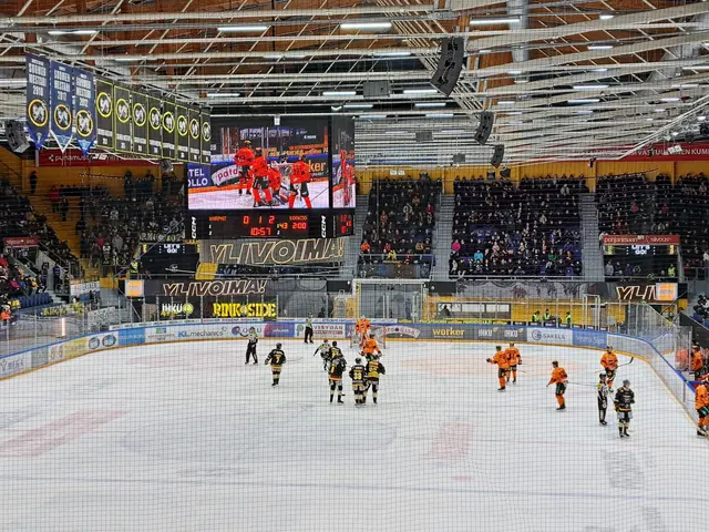 The image shows a group of people playing a game of hockey in a large arena. The arena is filled...