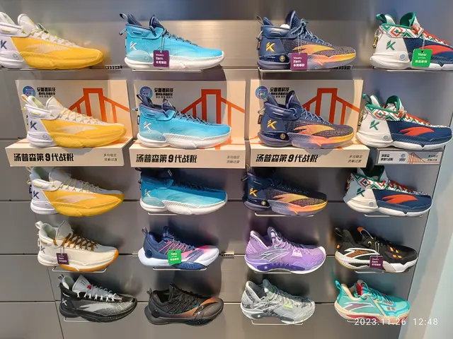 The image shows a display case filled with a variety of Reebok basketball shoes in different colors...