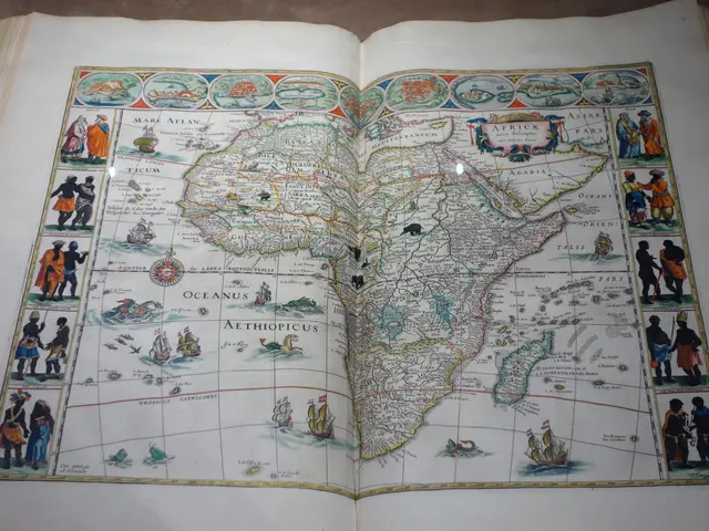 The image shows an open book with a map of Africa on it, placed on a surface. The map is detailed...
