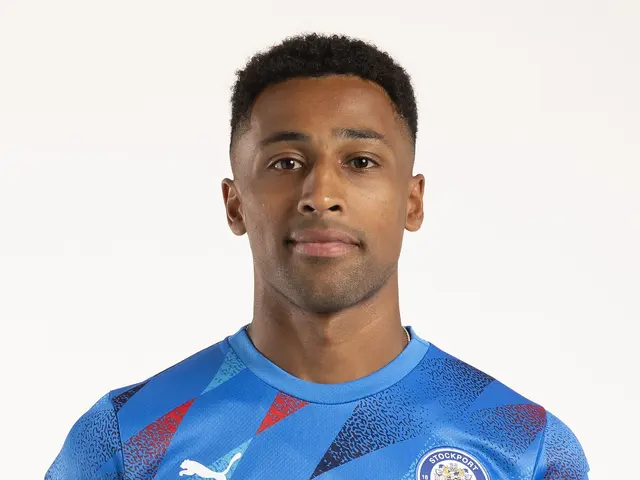 The image shows a man wearing a blue Leicester City Away Shirt from the 2019/20 season, with the...